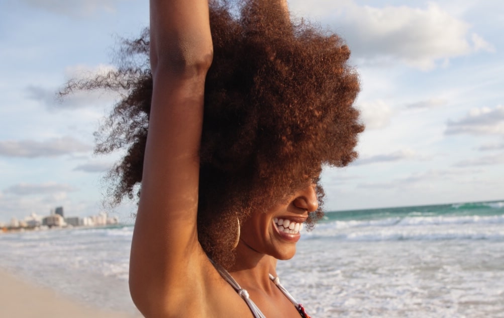 Young African American woman smiling on the beach